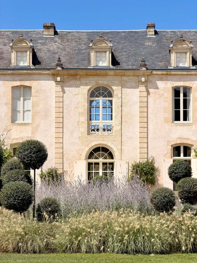 Façade en pierre calcaire blonde et toiture en ardoise